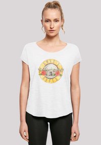 White short-sleeve t-shirt made of lightweight fabric featuring a circular Guns N' Roses graphic with roses and a gun motif in the center.