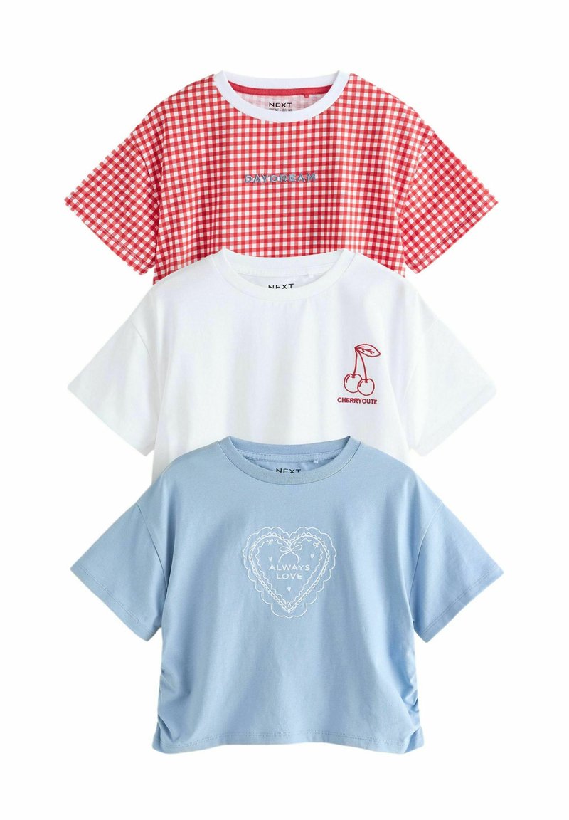 Tre t-shirts staplade: rödrutig, vit med körsbärsgrafik och blå med hjärtformad design. Bomullsmaterial, kort ärm, avslappnad passform.