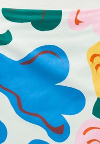 Abstrakt stoffmønster med store blå, grønne, rosa og gule blomsterformer på hvit bakgrunn, fremhevet med buede brune og oransje linjer.