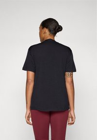 Sort T-shirt med korte ærmer, der har en rund halsudskæring og en afslappet pasform. Stoffet ser blødt ud med en subtil struktur.