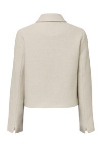 Beige Jacke, tailliert, aus strukturiertem Stoff, mit breitem Kragen, langen Ärmeln und seitlichen Schlitzen am Saum.