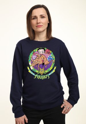 Marineblaues Sweatshirt mit einem bunten Grafikdesign, das einen Cartoon-Charakter, Blumenmuster und Elemente des Tierkreises zeigt. Lange Ärmel, Rundhalsausschnitt.