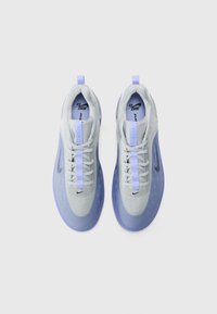 Lichtgrijze en lavendelkleurige sneakers met een mesh bovenkant, rubberen zool, vetersluiting en een opvallend Nike-logo aan de zijkant.