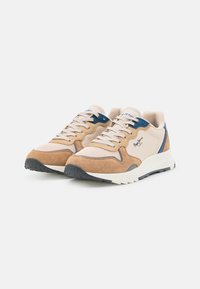Beżowa i brązowa para sneakersów z niebieskimi akcentami, białymi podeszwami, wykonana z siateczki i zamszu, z zapięciem na sznurówki na jednolitym białym tle.