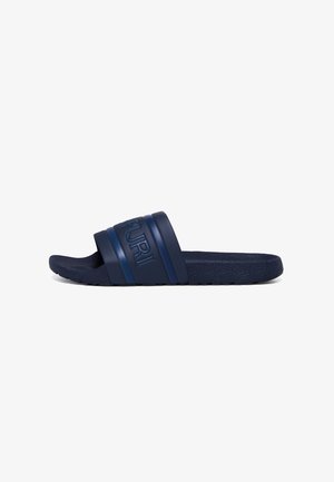 Blue slide sandal with a textured sole, featuring a wide strap and embossed brand name. Made of durable rubber material.