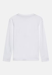 Långärmad vit t-shirt i bomull. Har en rund halsringning och mjuk textur. Ren, enkel design utan synliga grafik eller detaljer.