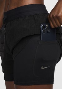 Čierne šortky Nike s textúrovanou, ľahkou vonkajšou vrstvou a pevným vnútorným dielom. Obsahujú bočné vrecko na mobilný telefón.