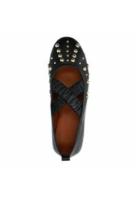 Chaussure en cuir noir avec bout rond, ornée de clous dorés sur le dessus, de lanières croisées plissées et d'un intérieur marron. Conception de semelle plate.