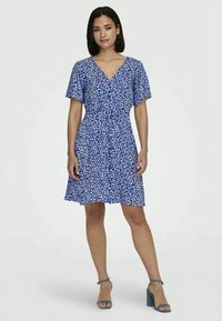 Vestido floral azul com mangas curtas, decote em V e cintura ajustada. Feito de um tecido leve, apresenta uma saia rodada e padrões subtis.