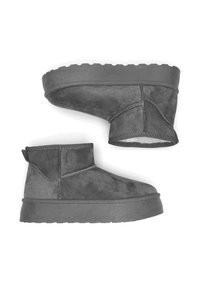 Botines de ante gris con suela gruesa de goma, detalles cosidos y una lengüeta en la parte trasera, con una textura suave y un diseño moderno.