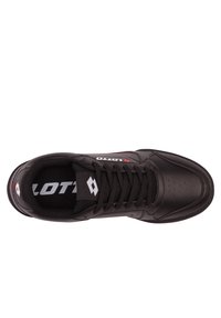 Czarne buty sportowe z gładką skórzaną cholewką, sznurowaniem, perforacjami dla wentylacji oraz kontrastowym białym logo na języku.