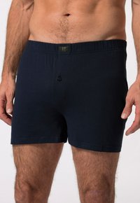 Námořnické modré bavlněné trenýrky s elastickým pasem, jedním knoflíkem a hladkou texturou, úzce padnoucí nad stehny.