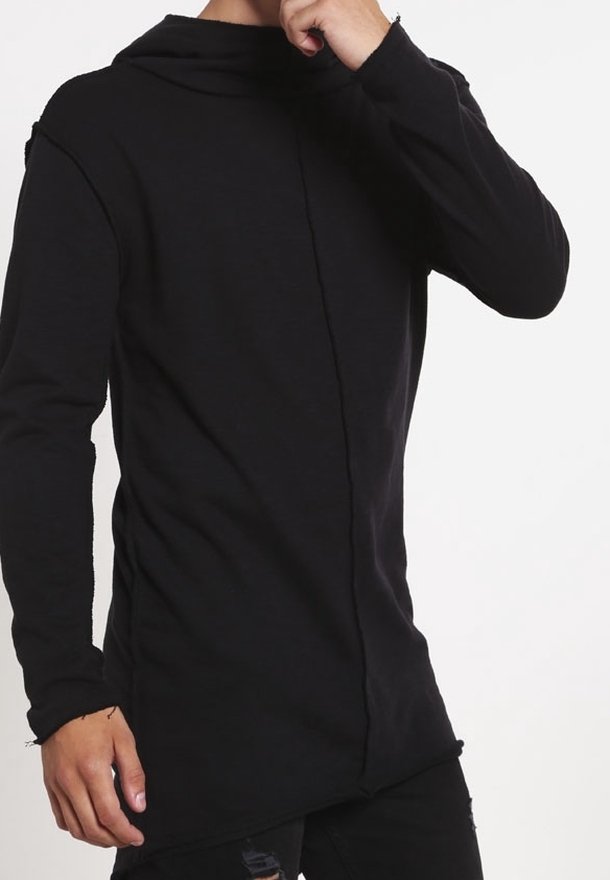 Camiseta negra de manga larga con capucha, hecha de un tejido suave. Presenta un dobladillo asimétrico único y un detalle de costura en la parte delantera.