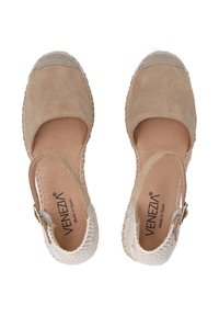 Beige suedette espadriller med vævede hvide detaljer, rund tå, ankelrem og struktureret sål af naturlige fibre. Mærkenavnet synligt indeni.