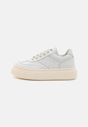 Fehér bőr sneaker, textúrázott krémszínű talppal, kerek orral és perforált részletekkel. Krémszínű fűzőkkel és minimalista designnel rendelkezik.