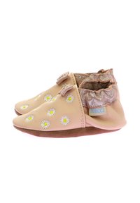Chaussures en cuir souple de couleur rose clair avec des marguerites brodées, un col volanté contrastant, une semelle flexible et une marque sur le côté.
