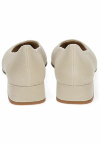 Scarpe in suede beige con tacco basso, retro arrotondato, superficie liscia e design minimalista. L'interno è foderato per il massimo comfort.