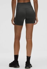 Juodos aukštai juosmens kompresinės šortai su lygiu paviršiumi ir siūlų detalėmis, turintys platų juosmens diržą ir prigludusį dizainą komfortui.