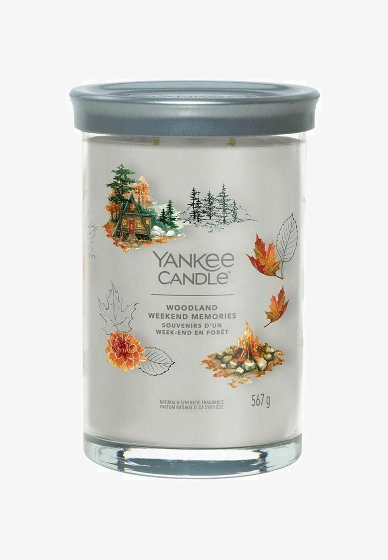Yankee Candle i en klar glasburk med ett grått lock. Illustrerad design som visar höstlöv, en stuga och en lägereld. Väger 567 g.