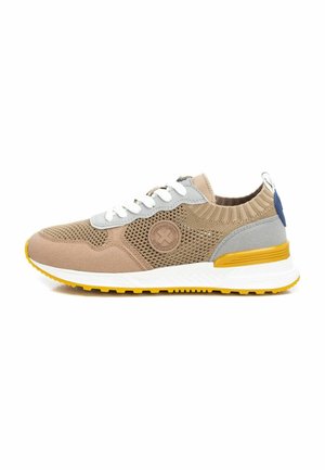 Zapatilla con parte superior de malla beige, acentos grises, cordones blancos y suela de goma amarilla. Cuenta con un parche de logo texturizado y un cuello acanalado.