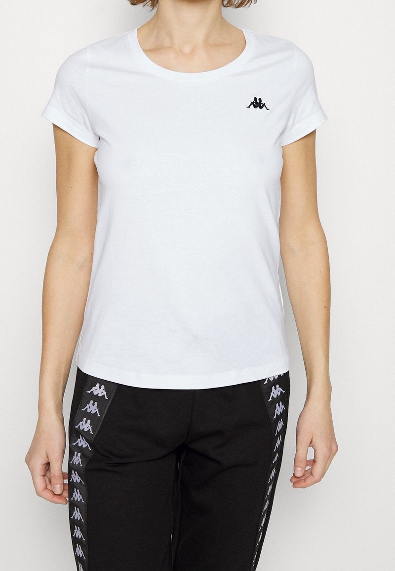 Bílý tričko s krátkým rukávem vyrobené z bavlny. Na levém prsu se nachází černé logo. Hladký povrch, klasický kulatý výstřih.