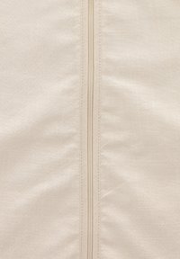 Beige Stoff mit subtiler Textur, der einen zentralen Reißverschluss aufweist. Das Material hat eine glatte Oberfläche mit leichtem Glanz.