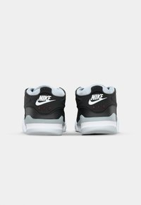 Zapatillas Nike Air en negro y gris con parte superior texturizada, cuellos acolchados y acentos en blanco; presenta un logotipo visible y suela acolchada.
