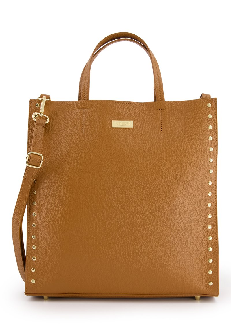 Sac fourre-tout en cuir marron avec des poignées arrondies, des accents en clous dorés d'un côté et une bandoulière amovible. Texture lisse et forme structurée.