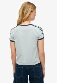 Hellgraues T-Shirt mit kurzen Ärmeln und dunkelblauem Besatz. Verfügt über einen runden Halsausschnitt und dezente Streifen an den Schultern. Weiche, glatte Stoffstruktur.