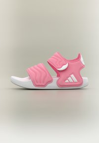 Roze sportsandalen met twee brede verstelbare riemen en witte accenten. Gemaakt van zacht materiaal, met een gestructureerd ontwerp en een rubberen zool.