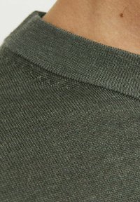 Țesătură tricotată de un verde închis, cu o textură netedă și un guler cu bordură, având variații fine de culoare și un detaliu curat al cusăturii.