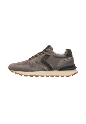 Grauer Wildleder-Sneaker mit braunen Akzenten, Schnürung vorne, gepolsterte cremefarbene Sohle und strukturierte braune Gummiaußensohle, von der Seite gezeigt.