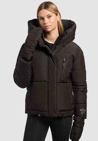 Veste matelassée noire avec une grande capuche, une poche poitrine zippée, des poignets élastiques et un ourlet à cordon de serrage. Design texturé et matelassé pour l'isolation.