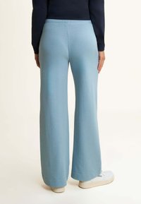 Helleblaue weit geschnittene Jogginghose aus weichem Material, mit einem bequemen elastischen Bund und ordentlichen Nähdetails.