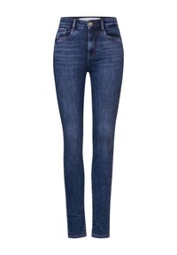 Jeans ajustados en denim azul oscuro, con una cintura alta, cinco bolsillos, costuras visibles y un cierre de botón en la parte superior.