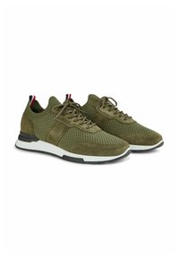 Baskets vert olive avec un dessus en mesh et en suède, bout rond, semelle en caoutchouc blanc, et accents contrastés rouges et bleus au niveau du talon.
