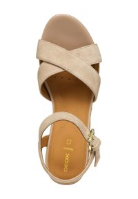Sandalo in suede beige con cinturini incrociati, punta arrotondata e soletta liscia color tan. Dotato di una fibbia dorata per una vestibilità regolabile. Design leggero.