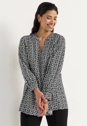 Zwart-wit gebloemde blouse met een notch halslijn, lange mouwen en een relaxte pasvorm. De stof lijkt glad met een geometrisch printontwerp.