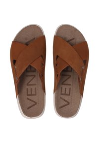 Bruine leren sandalen met een kruisriem ontwerp, voorzien van een gestructureerde binnenzool en een witte buitenzool. Metalen accenten bij de straps.