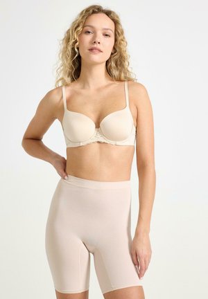 Beige polstret BH med blonder omkring og justerbare stropper, parret med højtaljede beige shorts, begge lavet af glat, strækbart materiale.