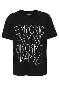 Černé bavlněné tričko s krátkým rukávem, které má bílý geometrický textový design a růžovou vyšitou nášivku na lemu. Volný střih.