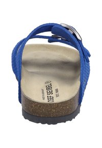 Blauwe suède sandaal met een gestructureerde band en een metalen gesp. Ergonomische kurken zool. Bruine voetbed met bedrukt logo, zwarte rubberen loopzool.