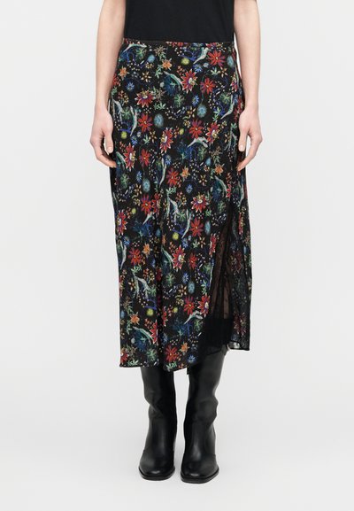 Svart midi-kjol med blommönster i färgstarka blommor och blad, med sidospalt och lätt tyg. Bärs med svarta knähöga stövlar.