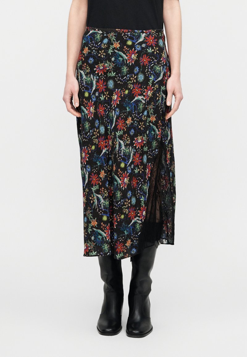 Μαύρη midi φούστα με floral σχέδιο σε πο λύχρωμα λουλούδια και φύλλα, με πλαϊνή σχισμή και ελαφρύ ύφασμα. Φοριέται με μαύρες μπότες μέχρι το γόνατο.