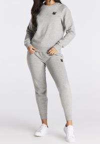 Grijze sweatshirt en bijpassende joggers gemaakt van een zachte katoenmengeling, met geribbelde manchetten en een klein zwart logo op de borst en dij.