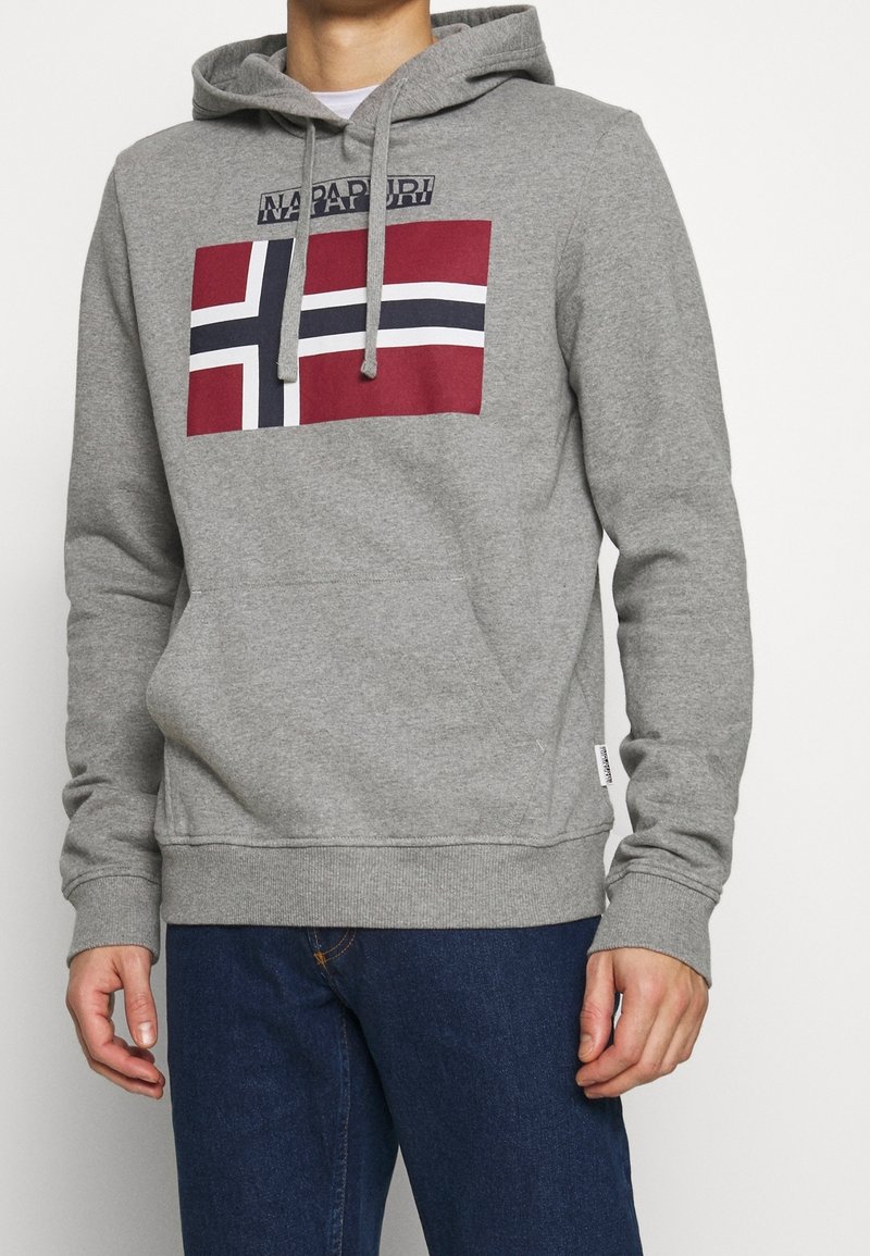 Sudadera gris con bolsillo tipo canguro, presenta un diseño de bandera noruega en rojo y azul marino, incluye cordones y puños de canalé.