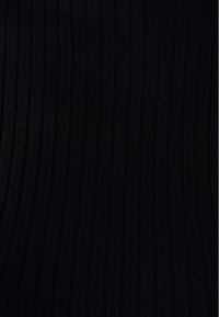 Tissu côtelé noir avec des rayures verticales, présentant une surface texturée. Le matériau paraît doux et extensible.