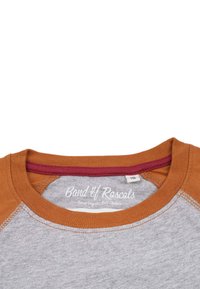 Grå t-shirt med orange raglanærmer og en maroon halsudskæring. Har "Band of Rascals" etiketten. Blødt bomuldsstof.