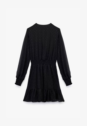 Vestido negro con mangas largas, cintura fruncida, dobladillo con volantes y tela texturada que presenta patrones sutiles a lo largo.