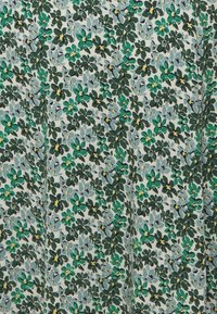 Tissu floral présentant un motif de fleurs vertes et bleues avec des accents jaunes sur un fond crème clair, texture lisse.